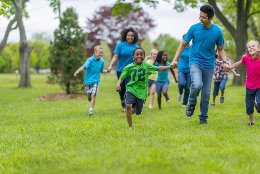 Kids and adults racing and holding hands.
